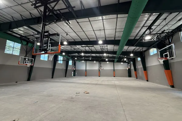 Green fabric duct distributing air across an open warehouse space