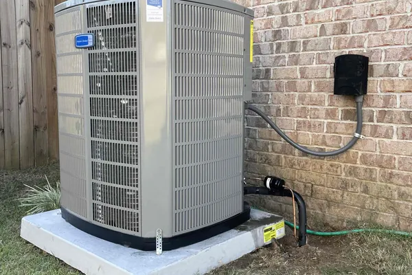 A residential condensing unit on a new concrete pad