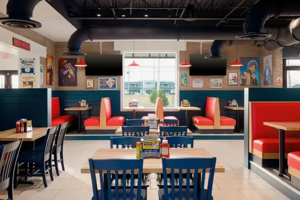 Ductwork and pendant lighting above restaurant booth seating