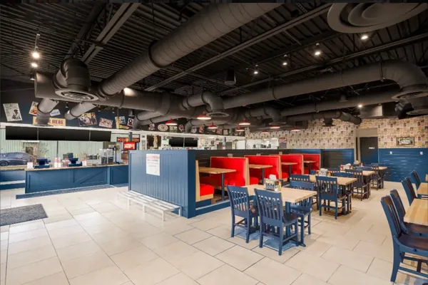 Exposed ductwork above a finished restaurant dining room