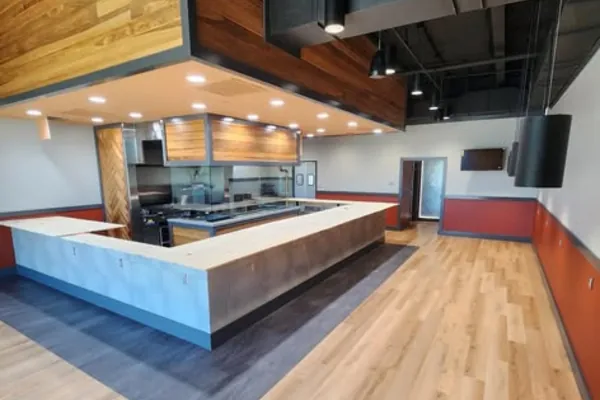 A wood-clad ceiling feature and ductwork above a restaurant service counter