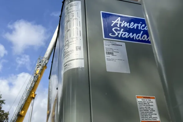 An American Standard rooftop unit rigged to a crane
