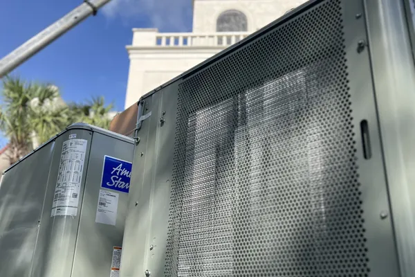 American Standard rooftop units staged beneath a crane