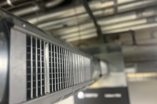A long run of exposed spiral ductwork across a commercial ceiling