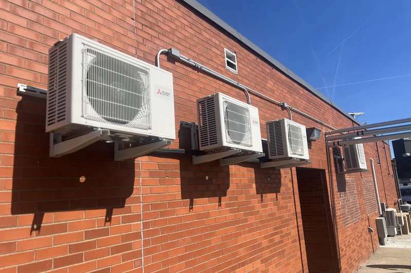 Commercial HVAC work by Climatech of Professional Air &mdash; a bank of Mitsubishi Electric ductless condensers mounted on a brick exterior wall