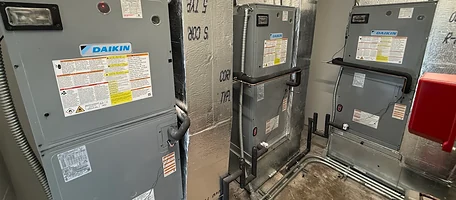 Three Daikin air handlers installed in a mechanical room with insulated ductwork