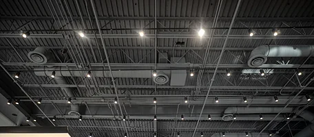 Exposed spiral ductwork and lighting in an open commercial ceiling