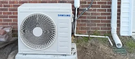 Samsung mini split outdoor condenser unit installed against a brick exterior wall